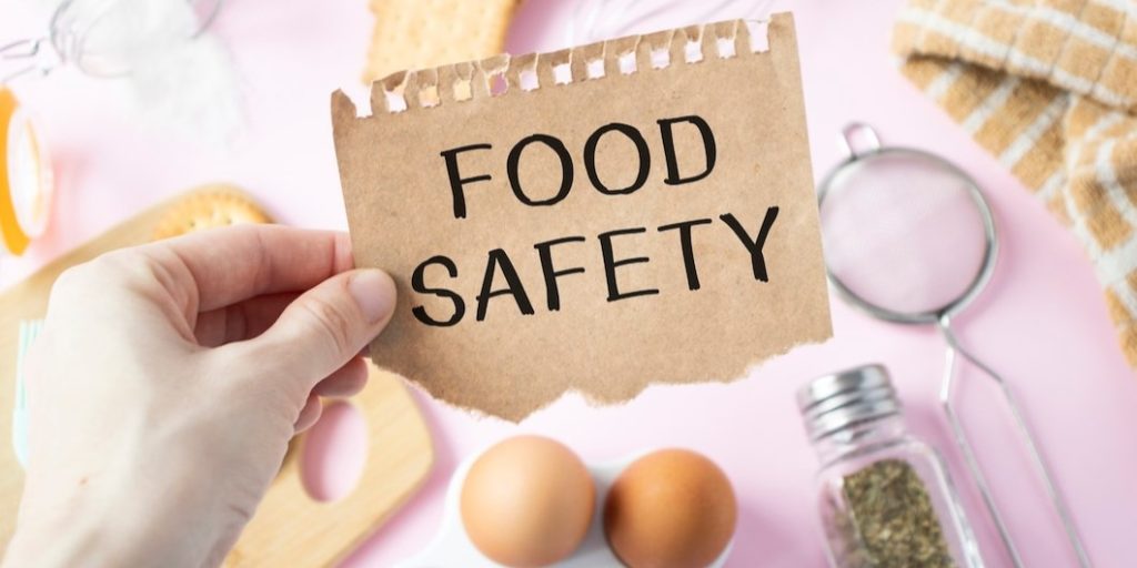 girl holds card with text food safety